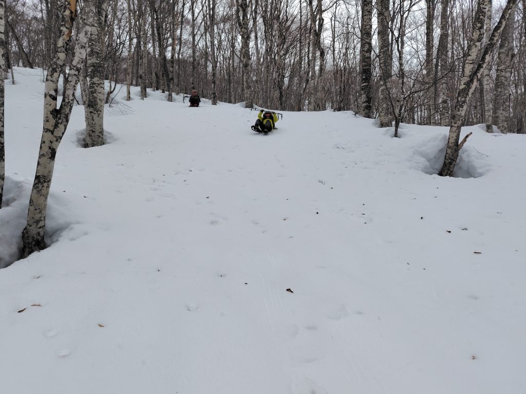 雪の斜面で尻滑り